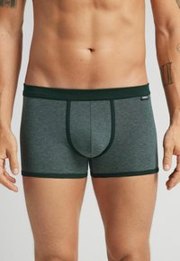 Grårandiga kalsonger med en mörkgrön midjeband och dekoren. Har en formad ficka och mjuk tygkänsla.