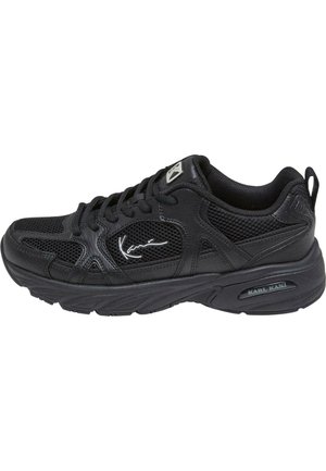 Scarpa sportiva nera con tomaia in mesh e accenti sintetici. Presenta lacci, un collo imbottito e una suola in gomma testurizzata. Dettaglio del logo sul lato.