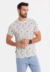 Hvid T-shirt med korte ærmer, der har et lineært sort tekstmønster. Lavet af blødt stof, med rund hals og let figursyet design.