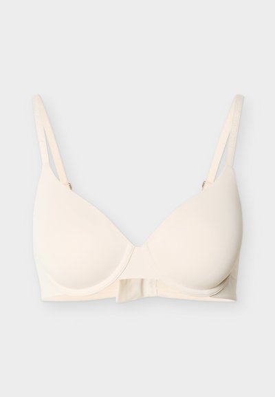 Μπεζ μπραζιέρ με μπανέλα και διαμορφωμένα cups, με ρυθμιζόμενα διπλά ράντες σε απλό ανοιχτό φόντο.