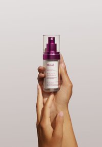 Sérum doux resurfaçant Murad Heartleaf dans un flacon en verre clair avec un bouchon-pompe violet, comportant du texte à l'avant et une texture lisse.