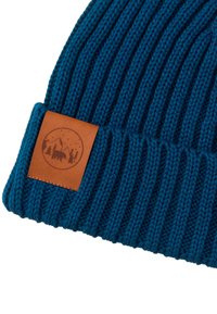 Niebieska prążkowana dziana czapka z podwiniętym mankietem i brązową skórzaną naszywką przedstawiającą górę, drzewa oraz sylwetkę niedźwiedzia.