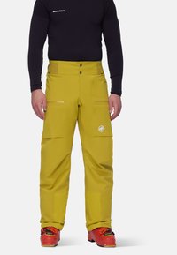Gele skibroek met twee voorzakken, ritsen en een logo. Gemaakt van waterdicht materiaal, voorzien van een verstelbare tailleband en verstevigde cuffs.