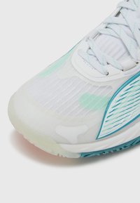 Białe buty sportowe z jasnoniebieskimi akcentami, teksturowaną siateczkową cholewką i gumową podeszwą. Charakteryzują się opływowym wzorem i zapięciem na sznurowadła.