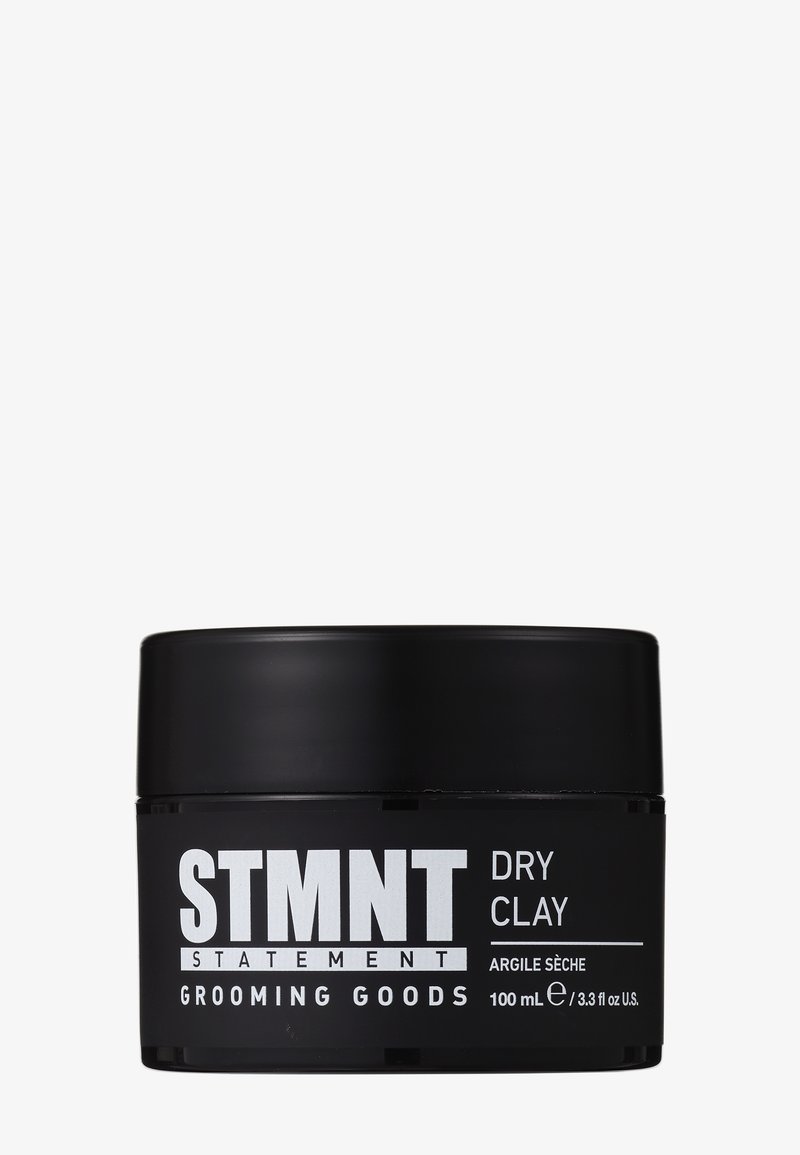Pot noir de STMNT Statement Grooming Goods Dry Clay, 100 ml, avec un texte blanc en gras sur un fond blanc uni.