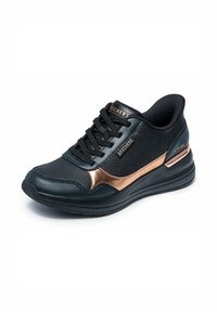 Zapatilla negra con parte superior texturizada, que presenta una franja de acento en rosa dorado, cordones planos negros y una suela acolchada para mayor comodidad.