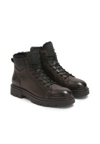 Botas de tobillo de cuero marrón oscuro con un acabado texturizado, diseño de cordones, forro interior acolchado y una suela de goma robusta.