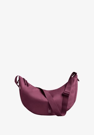 Sac hobo en bordeaux profond, fabriqué en tissu lisse. Dispose d'une bandoulière réglable et d'une fermeture éclair. Design minimaliste avec un détail de logo.