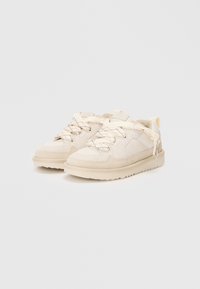 Sneakers beige con tomaia in suede e mesh testurizzato, punta rotonda, suola spessa e lacci leggeri. Dettaglio notevole: cuciture a contrasto.