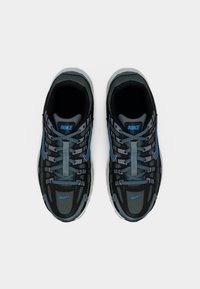 Μαύρα και γκρι αθλητικά παπούτσια Nike με μπλε λεπτομέρειες, επάνω μέρος από πλέγμα, κορδόνια και ελαστική σόλα με σχεδιασμένο μοτίβο.