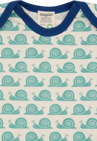 Bodysuit aus Bio-Baumwolle mit einem sich wiederholenden Muster von Türkisen Schnecken auf einem cremfarbenen Hintergrund und einem blauen Rippkragen.