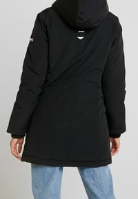 Black long parka with hood, featuring a cinched waist, zipper closure, and elastic cuffs. Back includes a silver hardware accent.