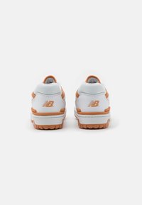 Zapatillas blancas con acentos naranjas, con una superficie texturizada, cuello acolchado y detalle del logo en el talón. Suela de goma para tracción.