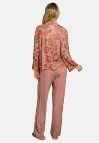 Floral-patterned pink blouse with long sleeves and matching striped pink pants. Soft fabric and relaxed fit for comfort.