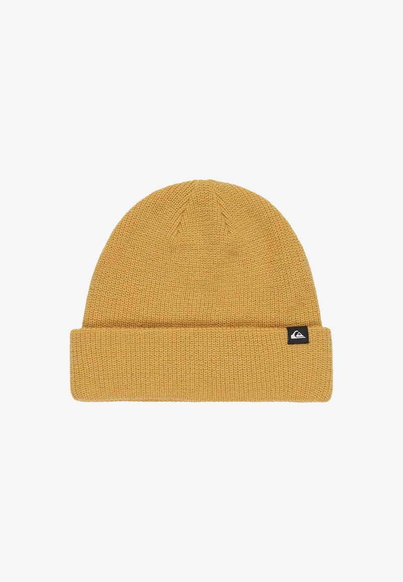 Mosterdgele gebreide beanie met omgeslagen rand en klein zwart logo-label aan de zijkant tegen een witte achtergrond.