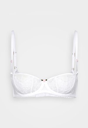 Soutien-gorge en dentelle blanche avec armatures, doté de bretelles réglables et d'un petit accent de fleur rose au centre. Bords en dentelle ondulés et détails en maille.