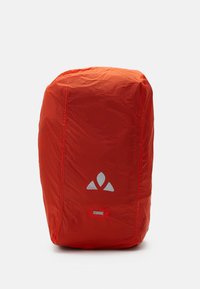 Zaino arancione brillante realizzato in un tessuto leggero e liscio. Presenta un logo riflettente e un dettaglio rosso nella parte inferiore.