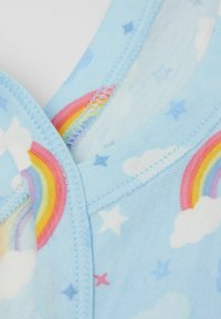 Světle modrá látka s vzory duhy a mraků, s výstřihem do V a šitými okraji. Měkká textura viditelná podél švů.