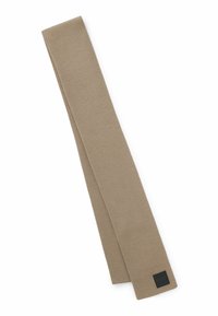 Beige strikket slips med en glat overflade, smalt design og et sort logo-mærke i den ene ende. Stof virker blødt og fleksibelt.