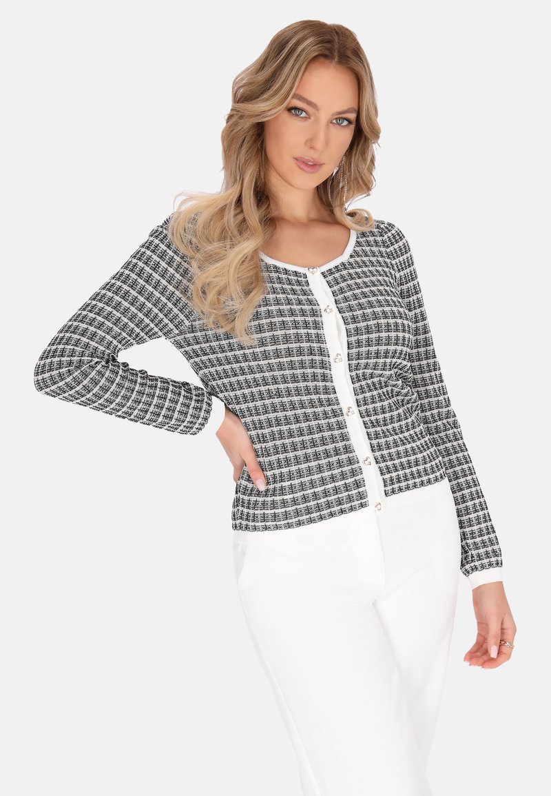 Fekete-fehér mintás kardigán hosszú ujjal, kerek nyakkivágással és elöl gombos záródással. Sima anyag, formázott fazon.