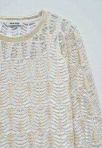 Pletena jopica z zlatim in belim odprtim vzorcem, z okroglim izrezom in teksturiranimi pletenjami ob ovratniku.