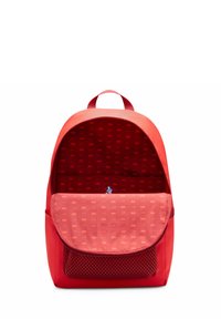 Zaino rosso con un'esterno texturizzato, una forma arrotondata e un interno spazioso che presenta una tasca in rete e un rivestimento con motivo.