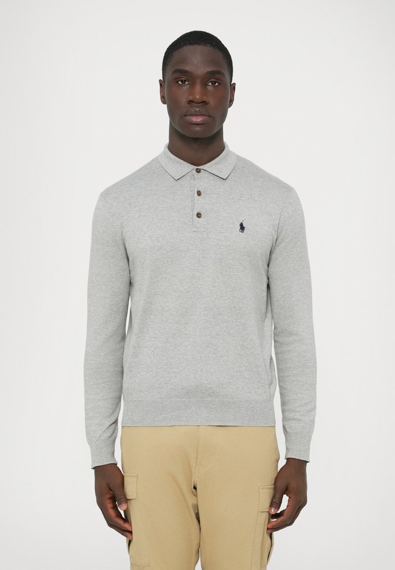 Szürke hosszú ujjú galléros póló, három barna gombbal és tengerészkék logóval. Puha anyagból, testhez simuló szabással.