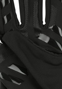 Zwarte handschoenen van een ademend materiaal met glanzende accenten en gestructureerde strepen. Het ontwerp bevat uitsparingen voor ventilatie.