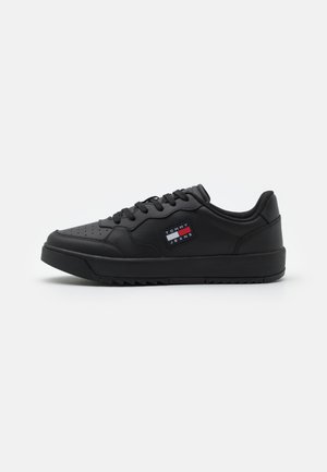 Sneaker nere con una tomaia sintetica liscia, punta rotonda, design perforato, lacci piatti e suola testurizzata. Presentano un'etichetta con il logo.