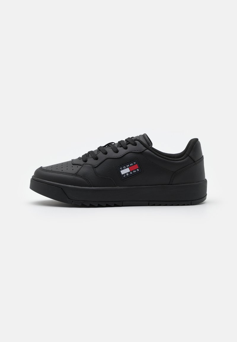Sneaker nere con una tomaia sintetica liscia, punta rotonda, design perforato, lacci piatti e suola testurizzata. Presentano un'etichetta con il logo.