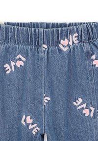 Pantalon en denim avec une taille élastique, ornés de textes "LOVE" rose éparpillés et d'accents de coeurs sur fond bleu.