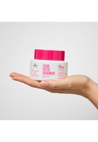 BC Color Freeze Treatment pH 4,5 i en vit burk med rosa lock, hålls i en hand. Etiketten inkluderar texten "200 mL" och "Clean Performance".