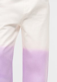 Balti kelnės su violetinės spalvos gradientu, prasidedančiu maždaug nuo šlaunies vidurio ir tęsiantis iki apačios, rodantios sklandų spalvos perėjimą audinyje.