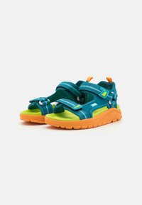 Teal og grønn sandal med oranså såle og stropper, med justerbare borrelås-lukkinger og tekstilmateriale for grep og komfort.