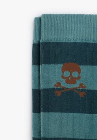 Calcetines a rayas en tonos verde azulado y azul oscuro con un diseño de calavera y tibias en marrón. Fabricados con un material de punto texturizado.