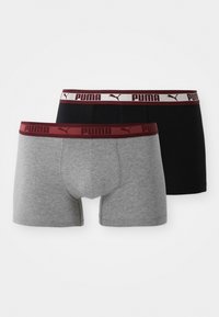 Két pár Puma boxer alsónadrág, egyik szürke, a másik fekete, mindkettő bordó elasztikus derékpánttal, amelyen a Puma logó és szöveg látható.