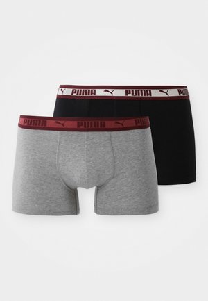 Dos pares de bóxer Puma, uno gris y otro negro, ambos con cinturillas elásticas en color marrón que muestran el logo de Puma y el texto.