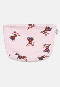 Ροζ υφασμάτινο πουγκί με επαναλαμβανόμενο σχέδιο καρικατούρων αρκούδων με ρούχα, με το κείμενο «guess» και γεωμετρικά σχήματα ως διακοσμητικό φόντο.