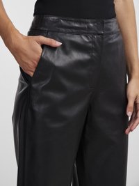 Zwarte leren broek met een soepel textuur, voorzien van zijzakken en een getailleerde pasvorm. De tailleband is strak en minimalistisch.