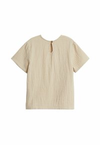 Beige kortärmad topp i en texturerad, skrynklig tyg, med ett nyckelhål vid ryggen, säkrad med en rund gul knapp.