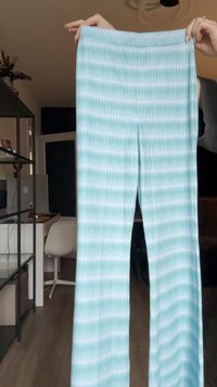 Light blue leggings with a wavy white pattern, textured fabric, elastic waistband, and wide-leg silhouette.