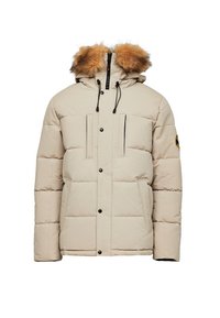 Veste d'hiver matelassée beige avec capuche bordée de fourrure, fermeture éclaire frontale et boutons-pression, deux poches verticales sur la poitrine et écusson sur la manche gauche.