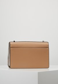 Torebka skórzana w kolorze tan, o prostokątnym kształcie, z fakturowaną powierzchnią, łańcuszkowym paskiem i minimalistycznym wzornictwie; posiada zapięcie na górze oraz kieszeń z tyłu.