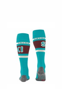 Türkisfarbene, kniehohe Skisocken mit kastanienbraunen und weißen Akzenten. Text mit den Worten "FALKE" und "SKI". Verfügen über strukturierte graue Sohlen für besseren Halt.