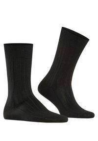 Chaussettes en coton noir avec une texture côtelée, présentant des talons et des orteils renforcés. Le design comprend des rayures verticales le long du corps.