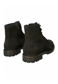 Botas de tobillo de ante marrón con cordones en la parte frontal, cremallera lateral y suelas de goma resistentes. Con costuras en contraste y un acolchado en el cuello.