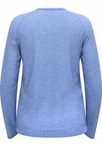 Chemise à manches longues en bleu clair, avec un motif texturé, col rond et une légère courbe à l'ourlet. Tissu lisse avec des manches raglan.