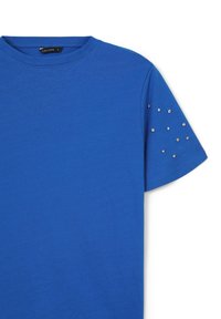 Camicetta blu brillante a maniche corte con colletto tondo e piccoli chiodini argentati sparsi sulla manica destra.