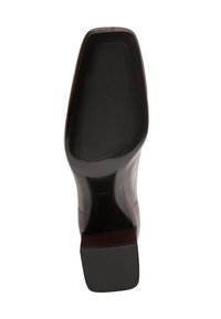 Suela de un zapato de vestir de cuero oscuro con un tacón cuadrado y área de agarre de goma texturizada.