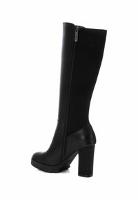 Bota negra hasta la rodilla con un acabado de cuero liso, tacón alto y grueso, cremallera lateral y punta redonda. Presenta una suela texturizada para mayor agarre.
